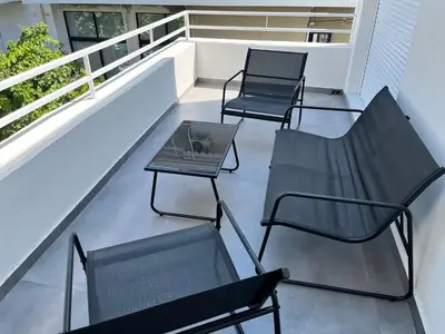 three chairs and a table on a balcony at White House Vouliagmeni 1- 2BD Free Parking, Next to the Sea in Athens