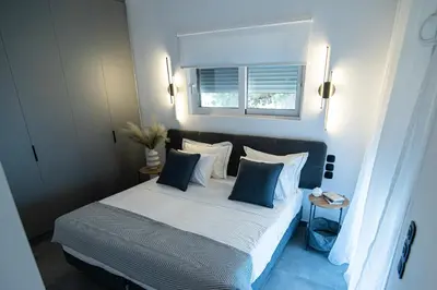 a bedroom with a bed with blue and white pillows at White House Vouliagmeni 1- 2BD Free Parking, Next to the Sea in Athens