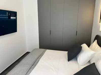 a bedroom with a bed with white sheets and pillows at White House Vouliagmeni 1- 2BD Free Parking, Next to the Sea in Athens