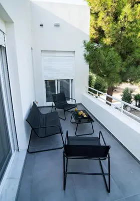 a patio with two chairs and a table on a balcony at White House Vouliagmeni 1- 2BD Free Parking, Next to the Sea in Athens