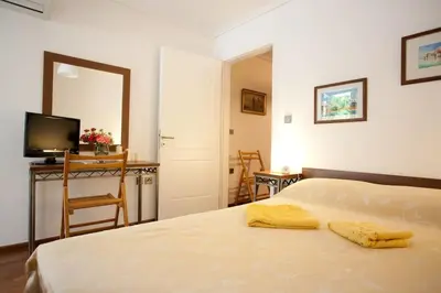 a bedroom with a bed and a table and a mirror at Veggie Garden Athens B&B in Athens