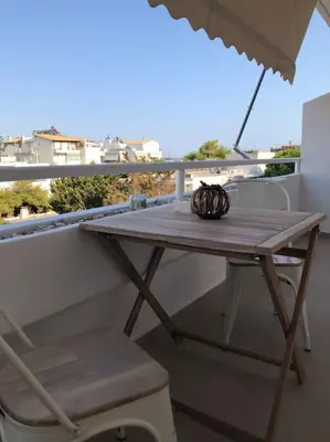 a table and chair on a balcony with an umbrella at Anastasia Suite/byArtistUnknown in Vari