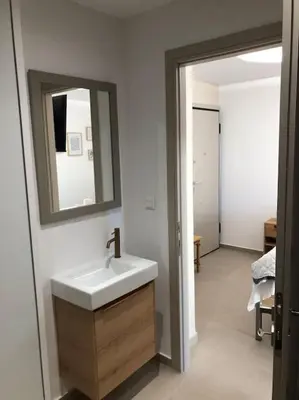 a bathroom with a sink and a mirror at Anastasia Suite/byArtistUnknown in Vari