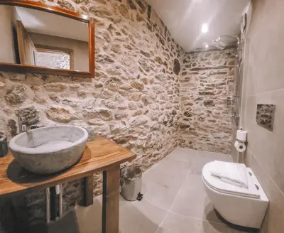 a stone bathroom with a sink and a toilet at The Cellar Studios - by Avelink in Spáta