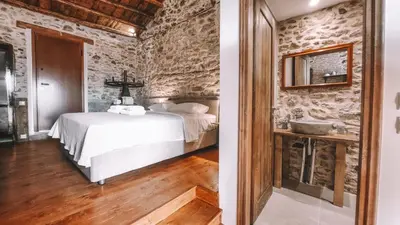 a bedroom with a bed and a stone wall at The Cellar Studios - by Avelink in Spáta