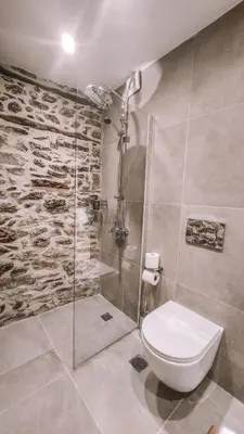 a bathroom with a toilet and a glass shower at The Cellar Studios - by Avelink in Spáta