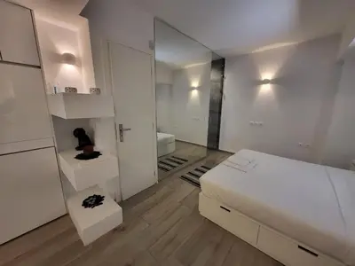a white bedroom with a bed and a mirror at Apartment Near The Center Of Glyfada in Athens
