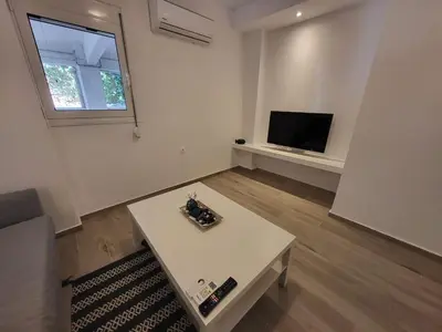 a living room with a table and a tv at Apartment Near The Center Of Glyfada in Athens