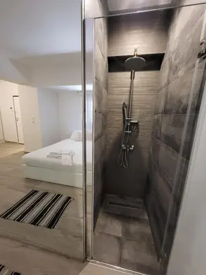 a bathroom with a shower and a bed in a room at Apartment Near The Center Of Glyfada in Athens