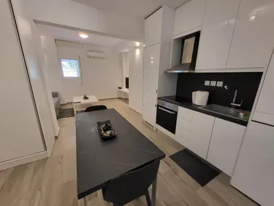 a kitchen with white cabinets and a black counter top at Apartment Near The Center Of Glyfada in Athens