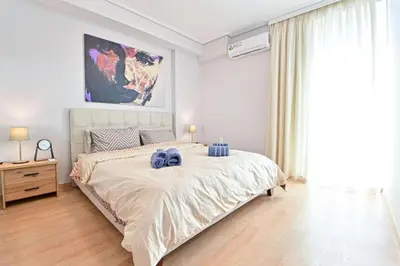 a bedroom with a large bed with blue pillows on it at Cozy apartment located on Piraeus Port area-(SPETS_D1) in Piraeus