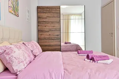 a pink bed with two towels and a mirror at Cozy apartment located on Piraeus Port area-(SPETS_D1) in Piraeus