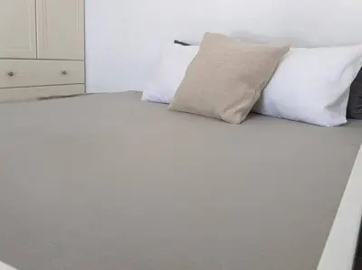 a bed with three pillows on top of it at Rooftop Studio with Acropolis & Sea view in Athens