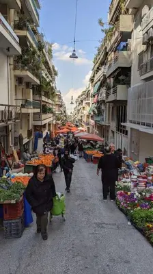 a group of people walking through an outdoor market at Rooftop Studio with Acropolis & Sea view in Athens