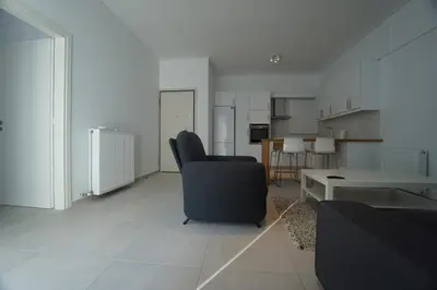 a living room with a chair and a table at Apartment For 4 Ppl In N. Smirni in Athens