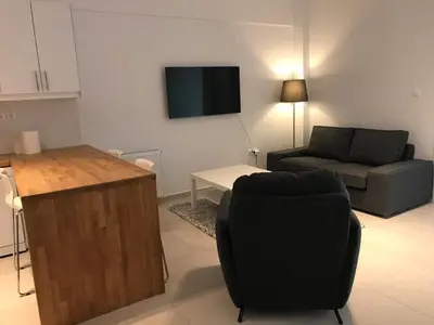 a living room with a couch and a chair and a television at Apartment For 4 Ppl In N. Smirni in Athens