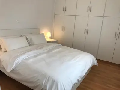 a white bed with white cabinets in a bedroom at Apartment For 4 Ppl In N. Smirni in Athens