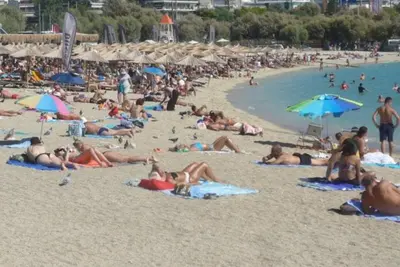 a large group of people laying on the beach at Studio47 in Athens