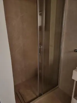 a shower with a glass door in a bathroom at Stylish studio in Glyfada in Athens