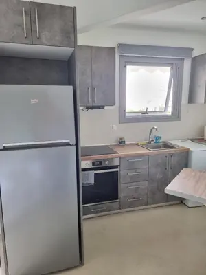 a kitchen with a white refrigerator and a window at Stylish studio in Glyfada in Athens