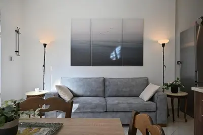 a living room with a couch and a picture on the wall at Seabreeze apartment in Palaio Faliro/ Netflix in Athens