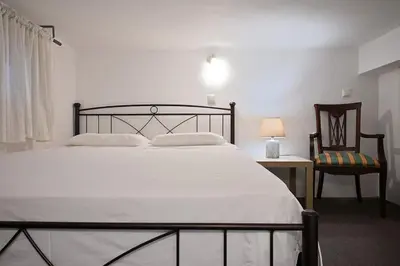 a bedroom with a bed and a chair and a lamp at Seabreeze apartment in Palaio Faliro/ Netflix in Athens