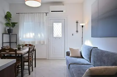 a living room with a blue couch and a table at Seabreeze apartment in Palaio Faliro/ Netflix in Athens