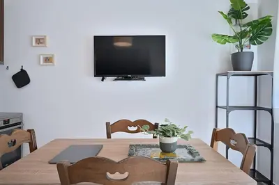 a dining room table with a television on a wall at Seabreeze apartment in Palaio Faliro/ Netflix in Athens