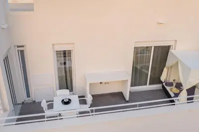 a room with white furniture on a balcony at White House Vouliagmeni 2-Free parking-next to the sea in Athens