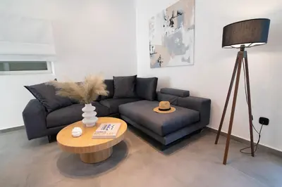a living room with a couch and a table at White House Vouliagmeni 2-Free parking-next to the sea in Athens