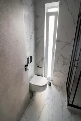 a bathroom with a white toilet and a window at White House Vouliagmeni 2-Free parking-next to the sea in Athens
