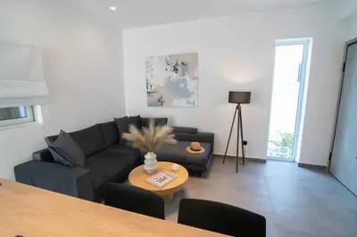 a living room with a couch and a table at White House Vouliagmeni 2-Free parking-next to the sea in Athens