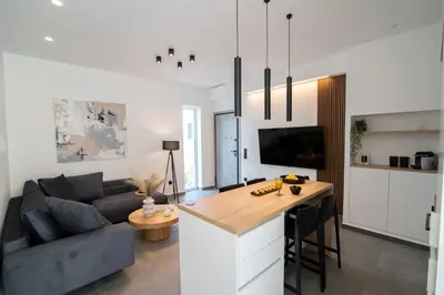 a kitchen and living room with a couch and a table at White House Vouliagmeni 2-Free parking-next to the sea in Athens