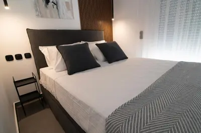 a bedroom with a large bed with black and white pillows at White House Vouliagmeni 2-Free parking-next to the sea in Athens