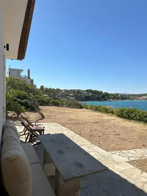 a picnic table on a patio with a view of the beach at Coast Cottage Porto Rafti-Avlaki by BRP-Properties in Porto Rafti