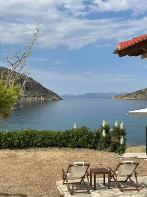 two chairs and a table next to the ocean at Coast Cottage Porto Rafti-Avlaki by BRP-Properties in Porto Rafti