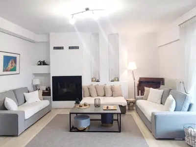 a living room with two couches and a table at Varkiza Sea View Apartment - Free Parking in Vari