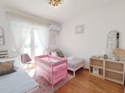 a bedroom with a pink crib and a desk at Varkiza Sea View Apartment - Free Parking in Vari