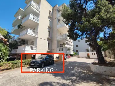 a car parked in a parking lot in front of a building at Varkiza Sea View Apartment - Free Parking in Vari