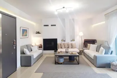 a living room with two couches and a table at Varkiza Sea View Apartment - Free Parking in Vari