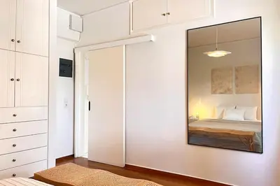 a bedroom with a large mirror on the wall at Pame Rentals - 1BD Apartment with Sea View in Athens