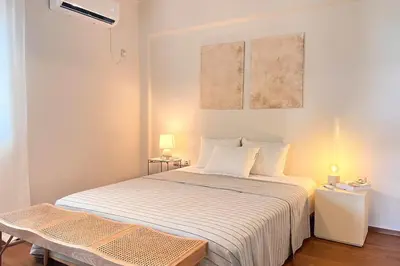 a small bedroom with a bed and a table at Pame Rentals - 1BD Apartment with Sea View in Athens