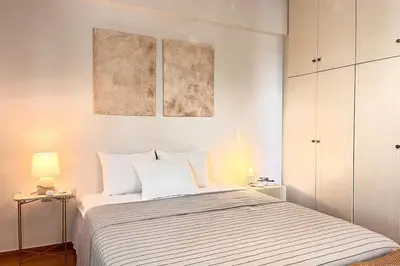 a bedroom with a bed with two paintings on the wall at Pame Rentals - 1BD Apartment with Sea View in Athens