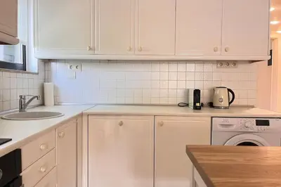a kitchen with white cabinets and a sink and a dishwasher at Pame Rentals - 1BD Apartment with Sea View in Athens