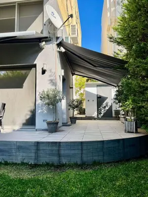 a patio with a black canopy on a building at Glyfada's Luxury Apartment in Athens