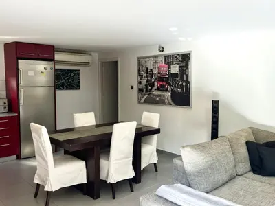 a dining room with a table and white chairs at Glyfada's Luxury Apartment in Athens
