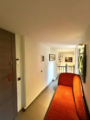 a living room with a red couch and a hallway at Glyfada's Luxury Apartment in Athens