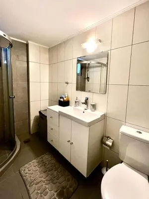 a bathroom with a sink and a toilet and a mirror at Glyfada's Luxury Apartment in Athens