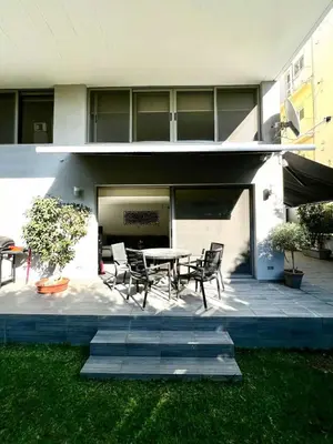 a patio with a table and chairs in front of a building at Glyfada's Luxury Apartment in Athens