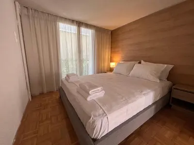 a bedroom with a bed with white sheets and a window at Family Apartment “Atene” in Athens